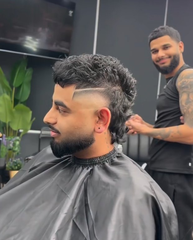 Curly mullet with a shaved part