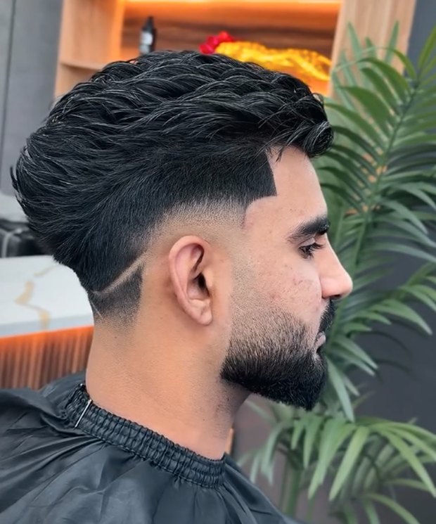 Slick textured top with a hard part and skin fade